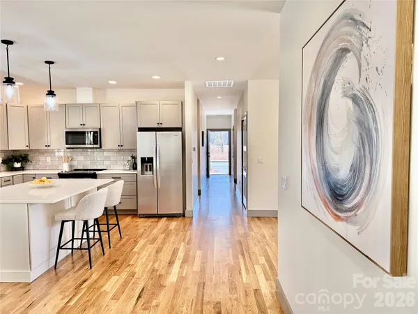 a view of an empty room with wooden floor and closet