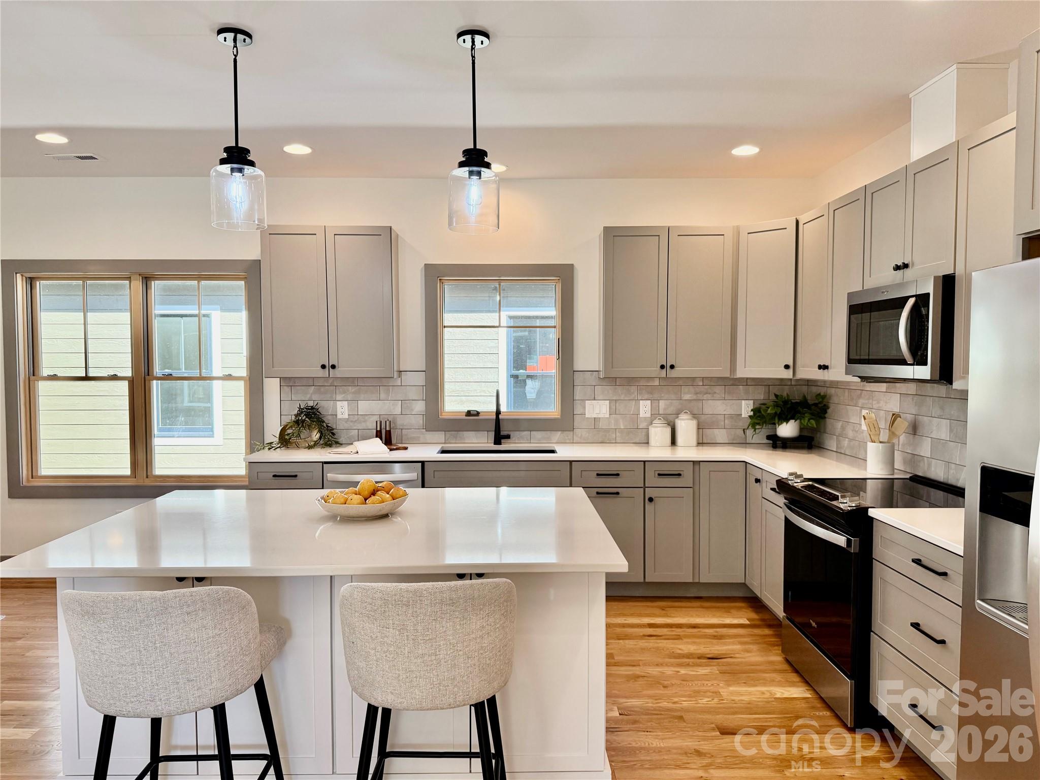 314 Gallimore Road Brevard, NC 28712 - Photo 7 of 38 a kitchen with stainless steel appliances granite countertop a stove top oven a sink dishwasher a dining table and chairs with wooden floor