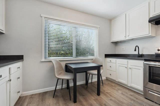 a kitchen with stainless steel appliances granite countertop a white cabinets and a stove top oven