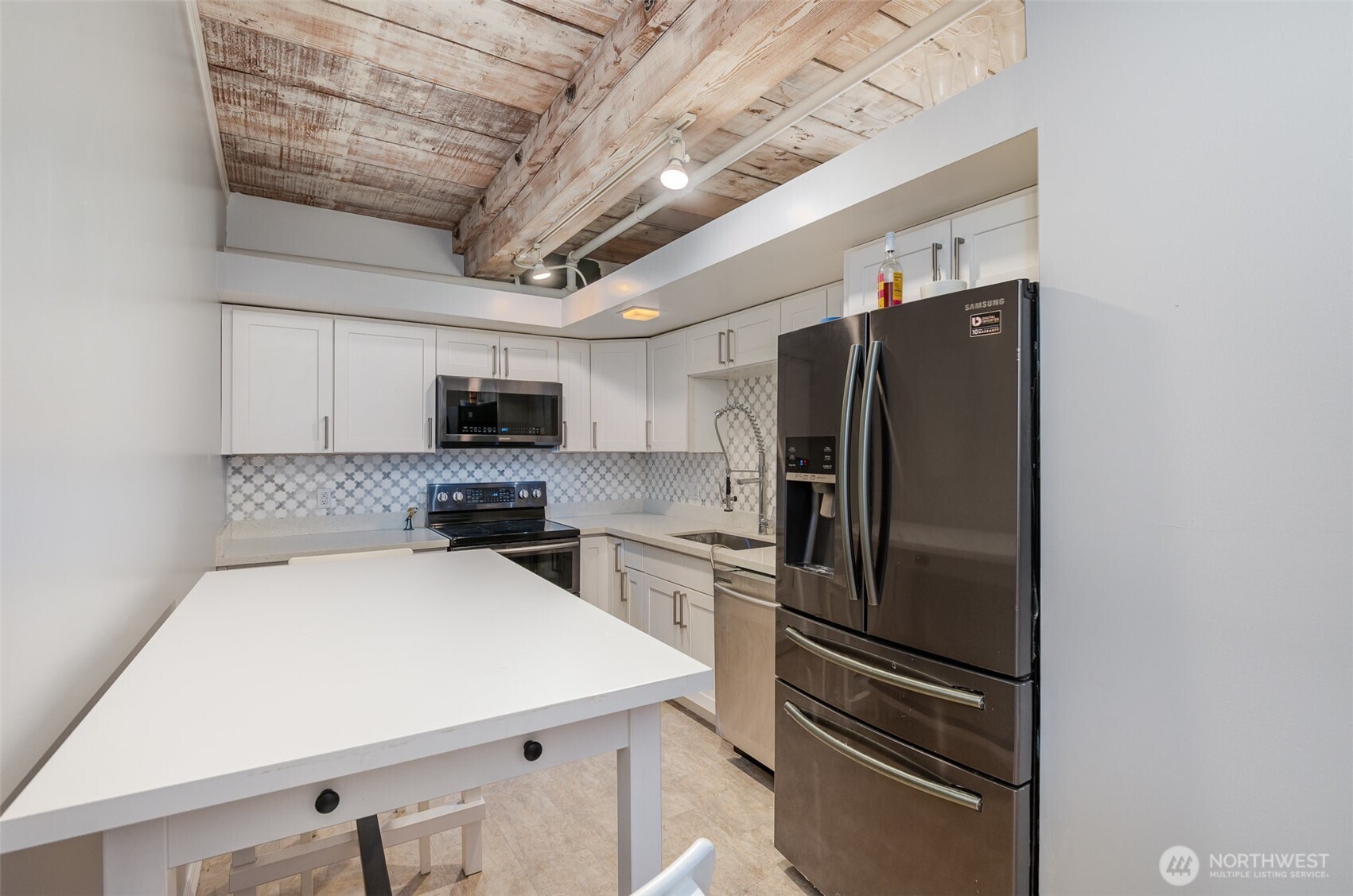 1507 Western Avenue, Unit R203 Seattle, WA 98101 - Photo 13 of 18 a kitchen with stainless steel appliances a refrigerator and a stove top oven