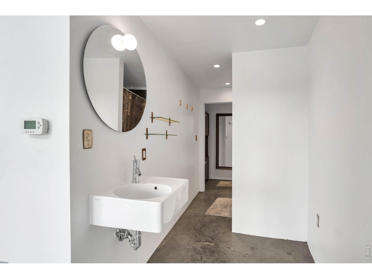 3457 Ringsby Court, Unit 327 Denver, CO 80216 - Photo 12 of 29 a bathroom with a sink a mirror and a shower