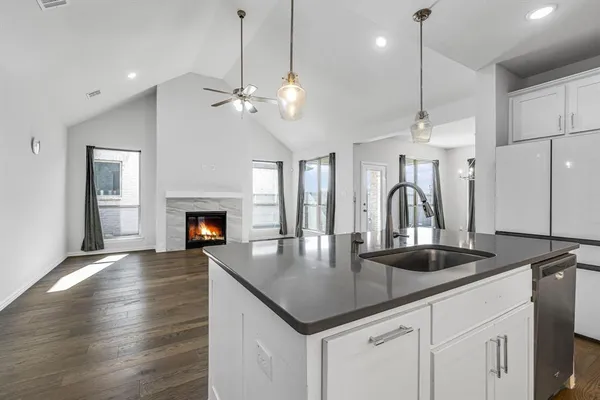 a kitchen with kitchen island granite countertop a sink a counter space and stainless steel appliances