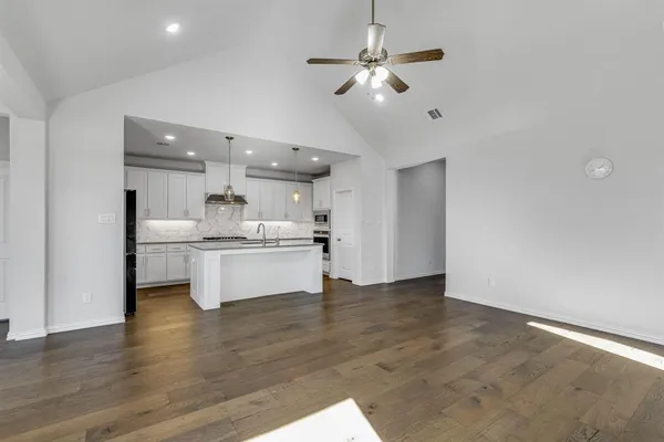 a view of kitchen with granite countertop cabinets and refrigerator