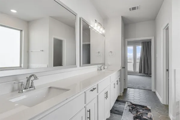 a bathroom with a double vanity sink and mirror
