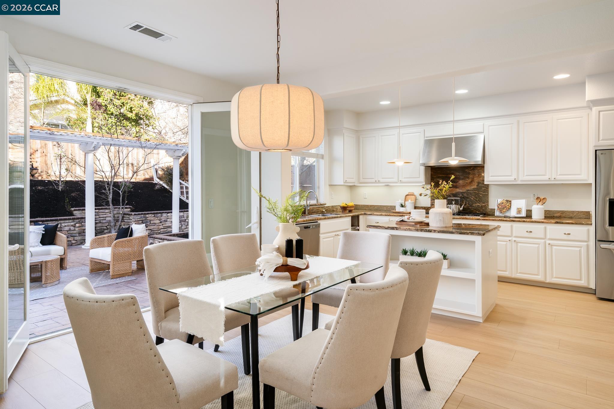 3138 Ashbrook Lane San Ramon, CA 94582 - Photo 8 of 27 a open kitchen with stainless steel appliances granite countertop a stove a refrigerator a kitchen island a table and chairs