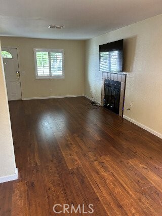 1743 Northview Place Paso Robles, CA 93446 - Photo 5 of 26 an empty room with wooden floor fireplace and windows
