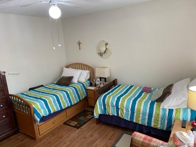 6857 Southwest 158th Pass Miami, FL 33193 - Photo 16 of 41 a bedroom with two beds and a lamp on dresser