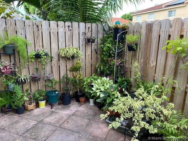 6857 Southwest 158th Pass Miami, FL 33193 - Photo 37 of 41 a potted plant sitting in front of a house with wooden fence