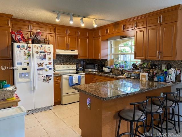 6857 Southwest 158th Pass Miami, FL 33193 - Photo 6 of 41 a kitchen with stainless steel appliances granite countertop a refrigerator a stove a sink and a microwave