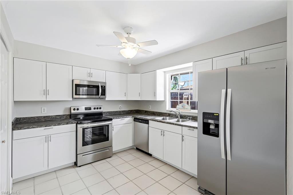 4402 Pine Lake Road Bonita Springs, FL 34134 - Photo 2 of 16 a kitchen with stainless steel appliances cabinets a sink and a stove