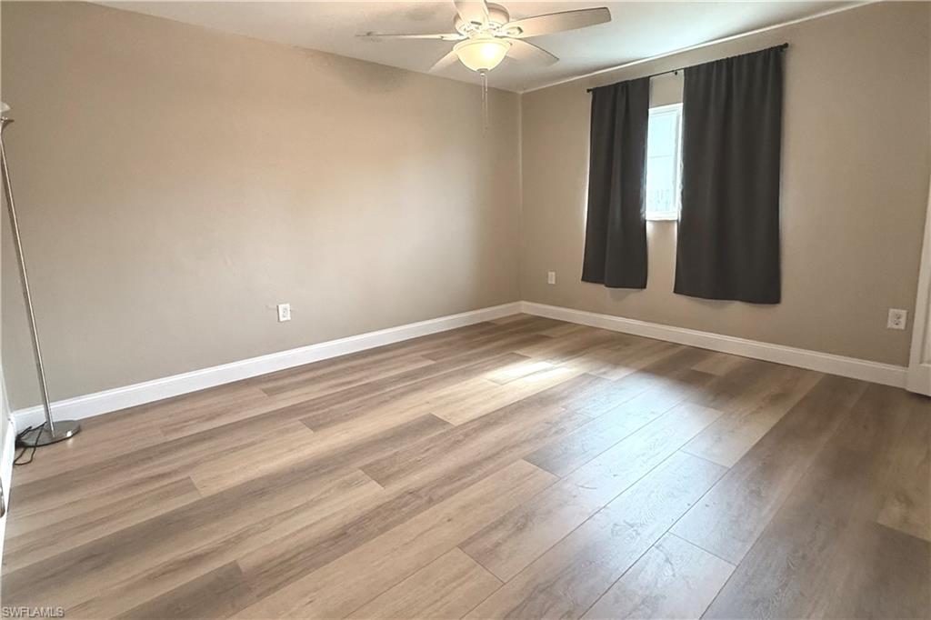 4402 Pine Lake Road Bonita Springs, FL 34134 - Photo 5 of 16 wooden floor in an empty room with a window