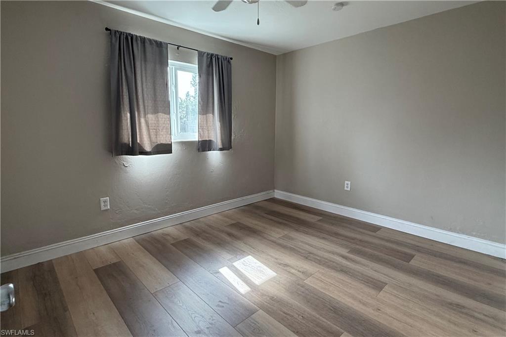 4402 Pine Lake Road Bonita Springs, FL 34134 - Photo 8 of 16 wooden floor in an empty room with a window