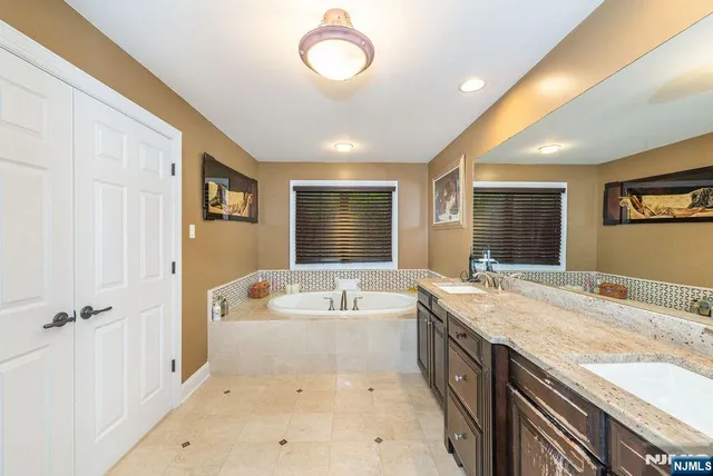 a spacious bathroom with a granite countertop tub sink and mirror