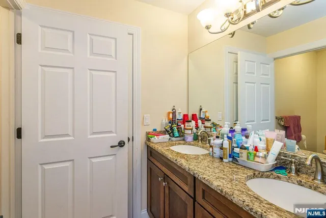 a bathroom with a granite countertop sink a mirror and a shower
