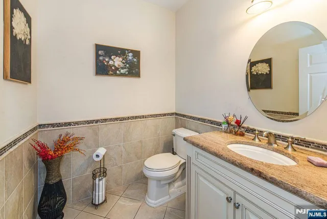 a bathroom with a granite countertop sink mirror vanity and toilet