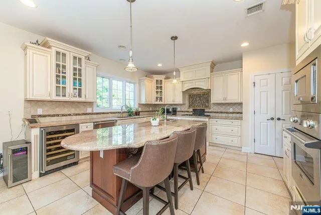 a kitchen with stainless steel appliances granite countertop a stove a sink a refrigerator and a microwave