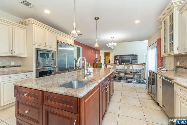 a kitchen with stainless steel appliances granite countertop a sink counter space cabinets and a stove