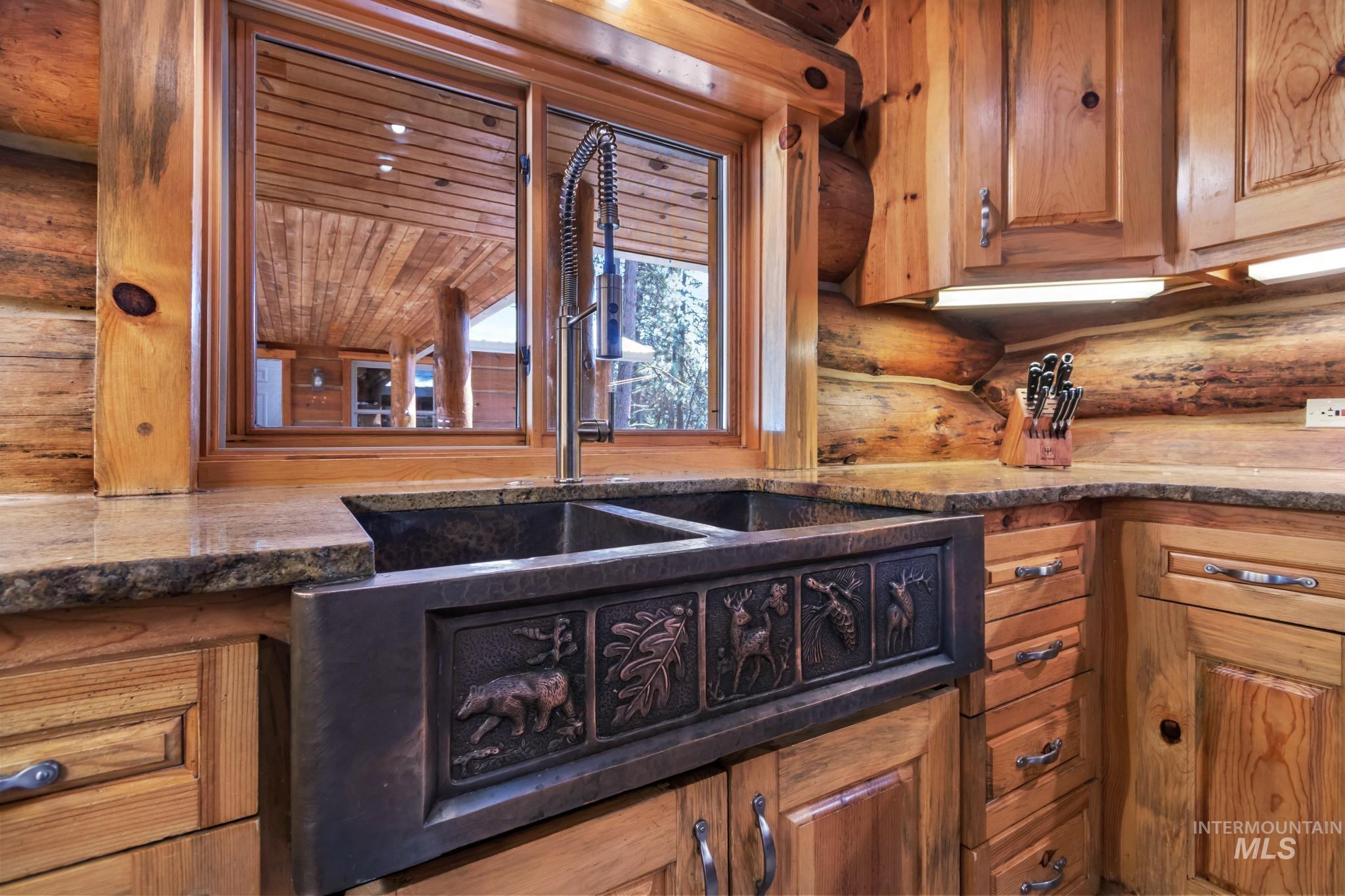 85 Pine Top Road Boise, ID 83716 - Photo 14 of 33 Kitchen featuring a double basin farmhouse sink with embossed wildlife detailing, a gooseneck faucet, light wood cabinetry, and stone countertops
