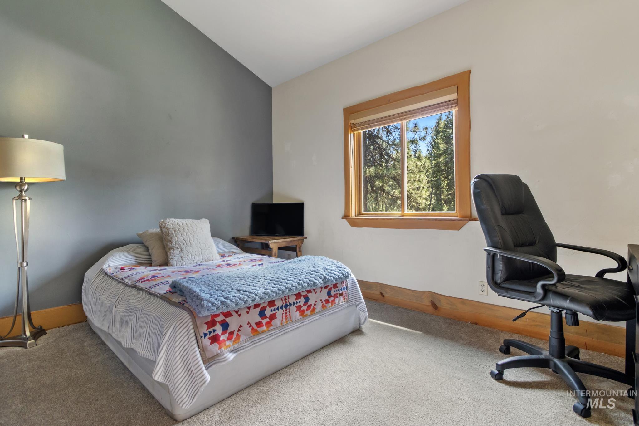85 Pine Top Road Boise, ID 83716 - Photo 21 of 33 Carpeted room featuring a window with natural wood trim, a neutral wall color, and an accent wall
