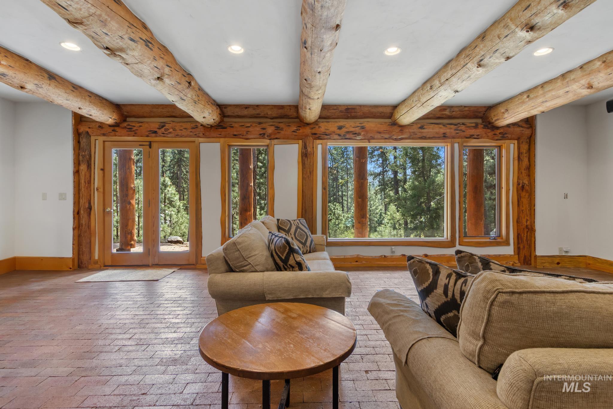 85 Pine Top Road Boise, ID 83716 - Photo 26 of 33 Spacious room featuring exposed log beam ceilings and brick-patterned flooring