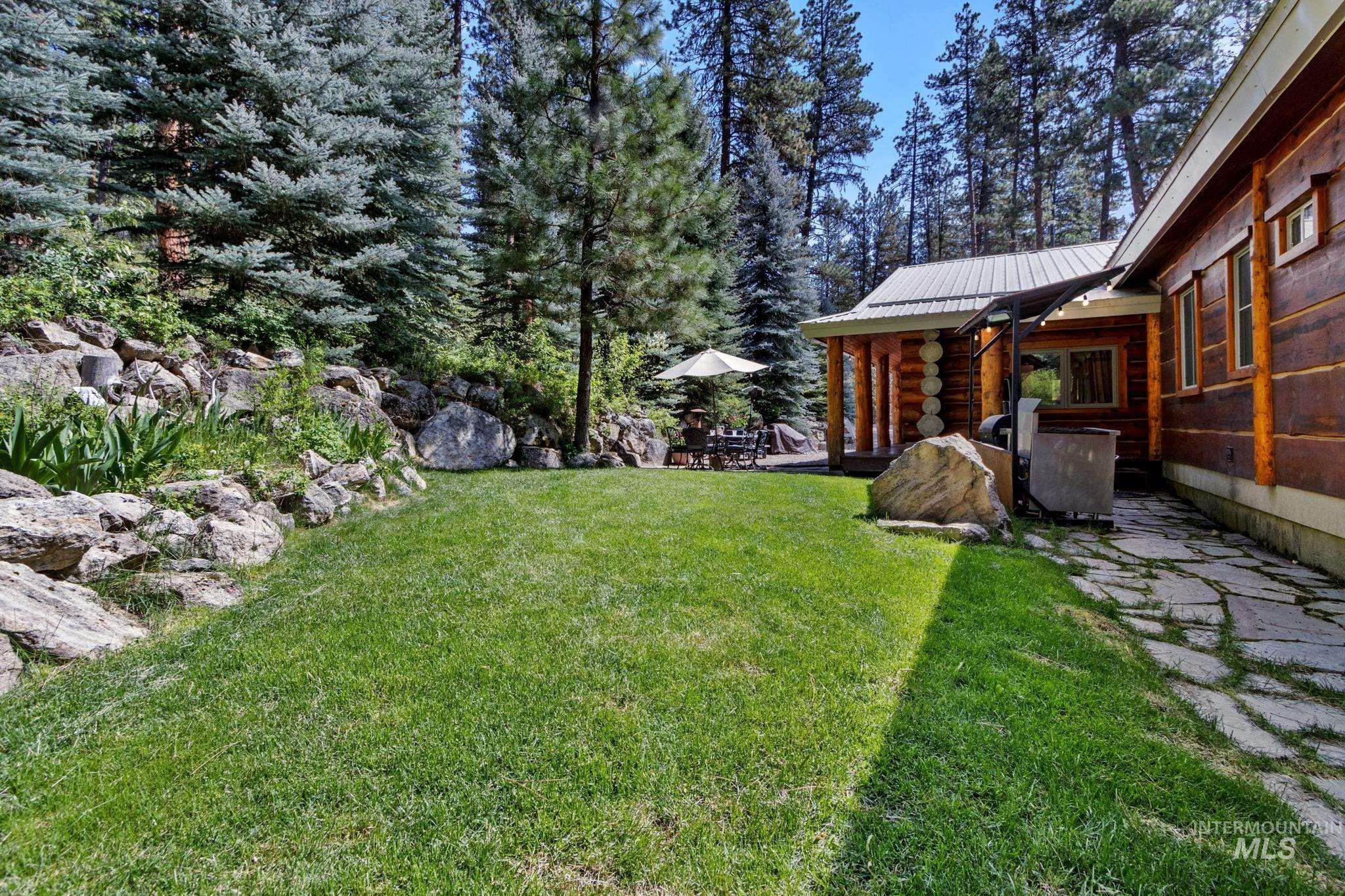 85 Pine Top Road Boise, ID 83716 - Photo 28 of 33 Expansive lawn area bordered by natural rock landscaping and mature evergreen trees