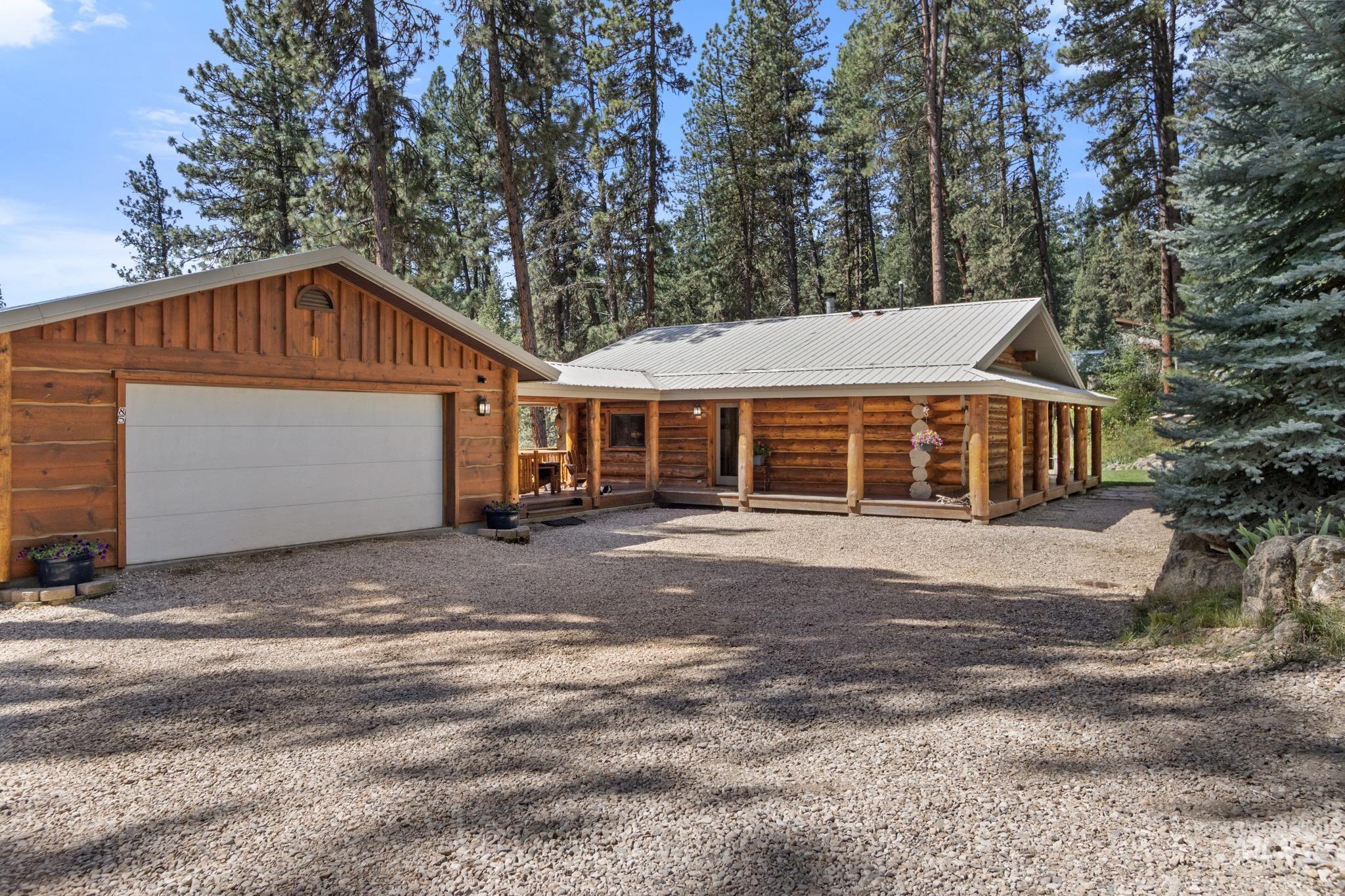 85 Pine Top Road Boise, ID 83716 - Photo 3 of 33 Log cabin residence with an extended covered porch and a detached two-car garage