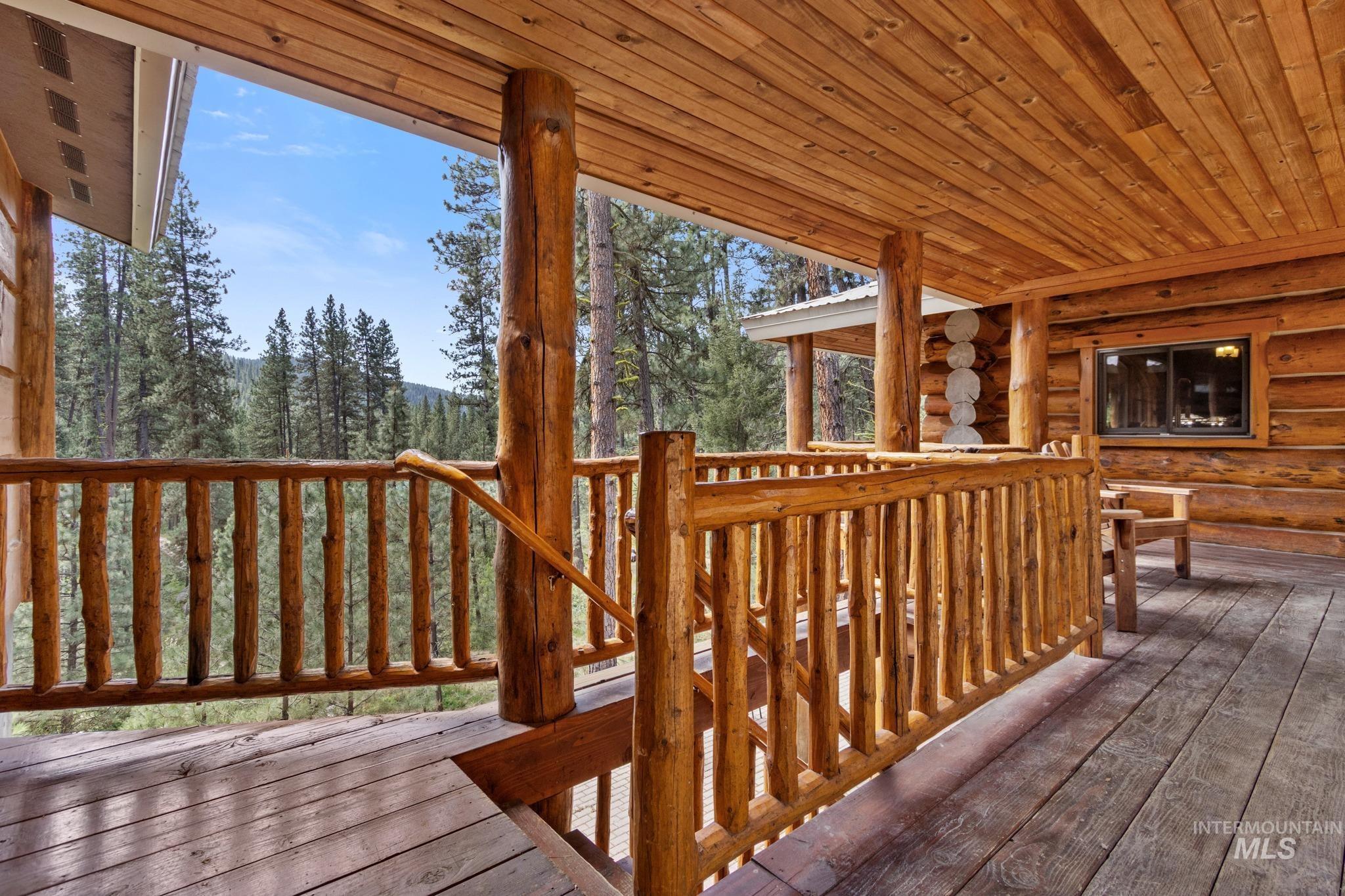 85 Pine Top Road Boise, ID 83716 - Photo 6 of 33 Expansive wood deck featuring a natural log railing system, solid wood support beams, and a wood-plank ceiling