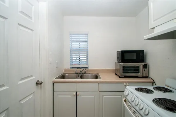 a kitchen with sink stove and microwave