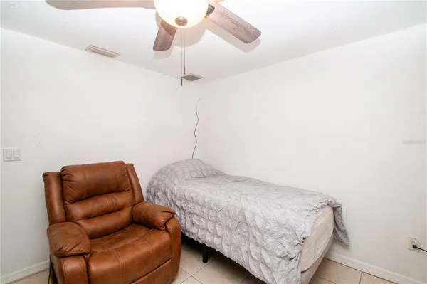 a bedroom with a bed couch and a window