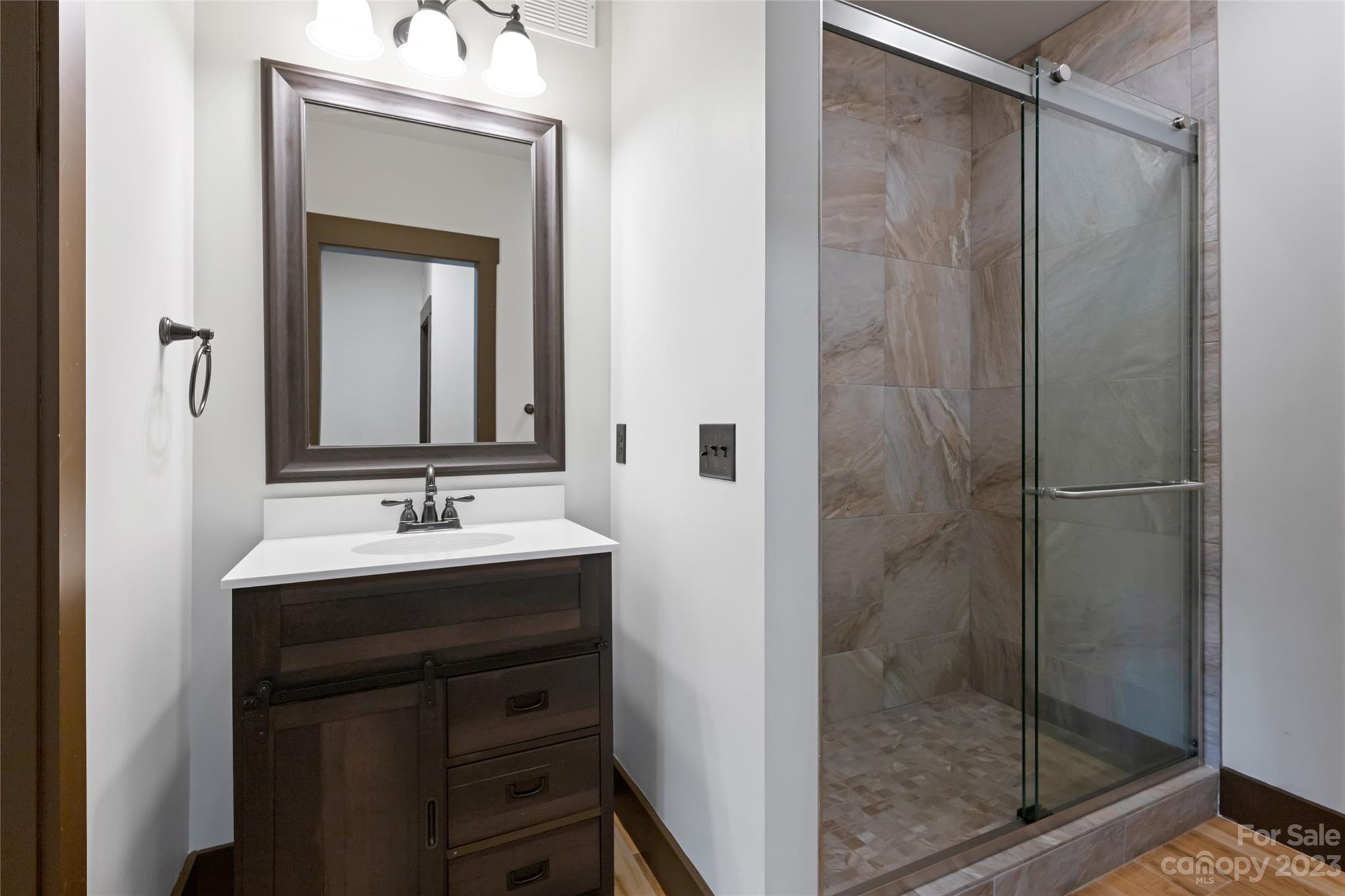 1025 Morgan Hill Road Black Mountain, NC 28711 - Photo 31 of 48 a bathroom with a shower sink and mirror