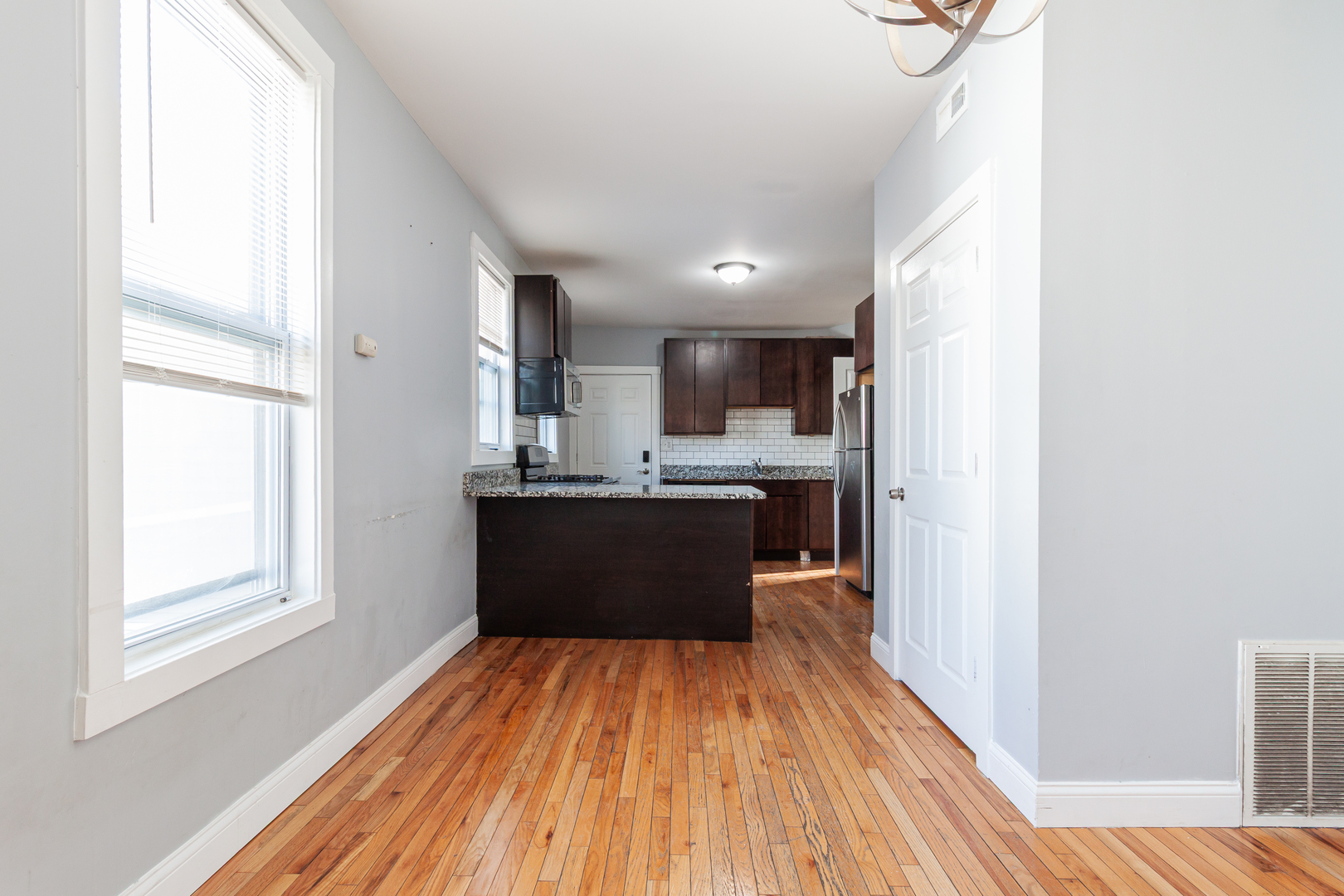 2968 North Ridgeway Avenue, Unit 2R Chicago, IL 60618 - Photo 14 of 23 a large kitchen with a window wooden floor stainless steel appliances and cabinets