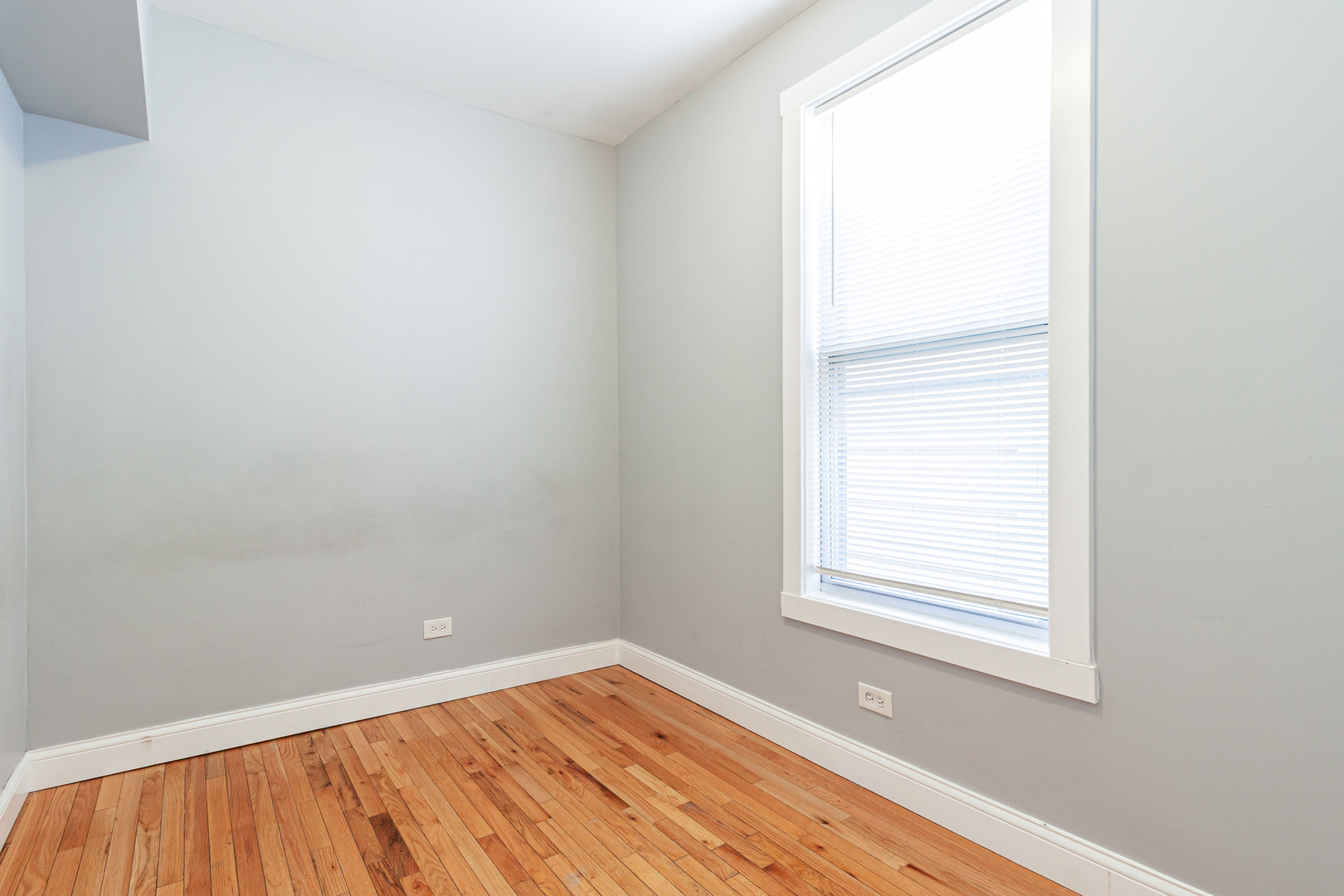 2968 North Ridgeway Avenue, Unit 2R Chicago, IL 60618 - Photo 18 of 23 a view of an empty room with wooden floor and a window
