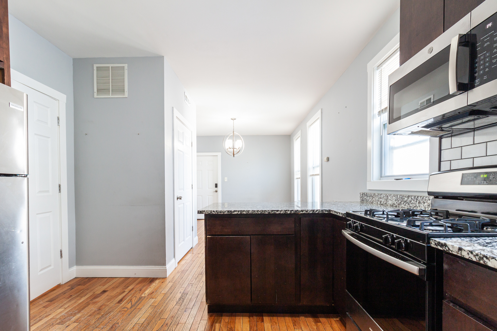 2968 North Ridgeway Avenue, Unit 2R Chicago, IL 60618 - Photo 4 of 23 a kitchen with granite countertop wooden cabinets and a stove