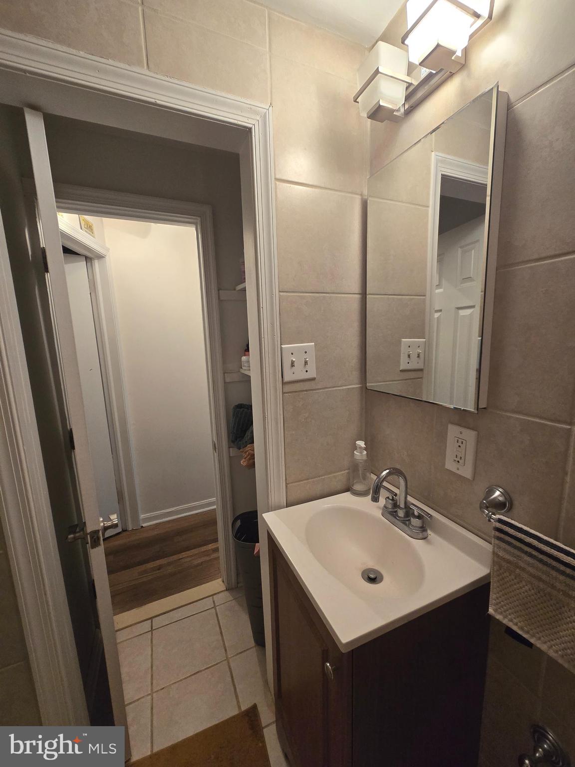 1413 Lombard Street, Unit 2R Philadelphia, PA 19146 - Photo 11 of 14 a bathroom with a sink a mirror a vanity and a shower