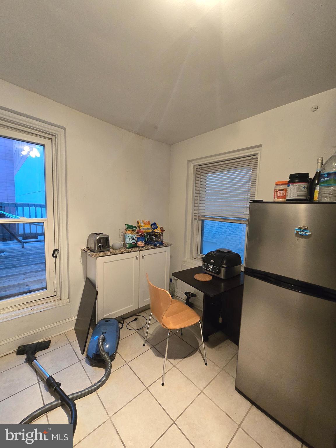 1413 Lombard Street, Unit 2R Philadelphia, PA 19146 - Photo 5 of 14 a living room with a couch and a dining table with appliances