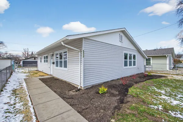 a view of a house with backyard and sitting area