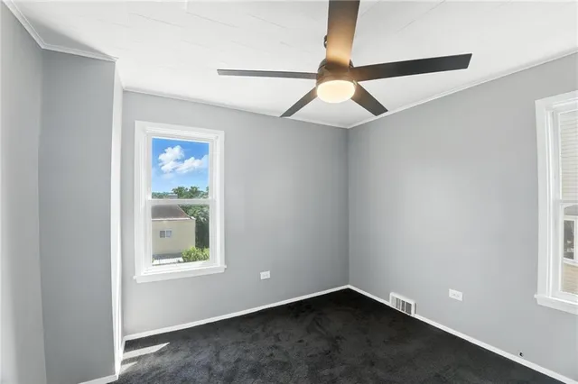 an empty room with windows and fan
