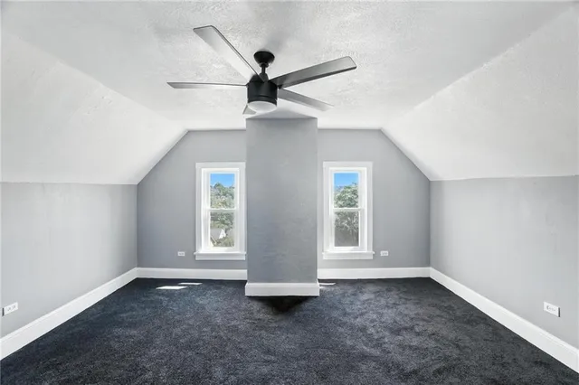 an empty room with ceiling fan and window
