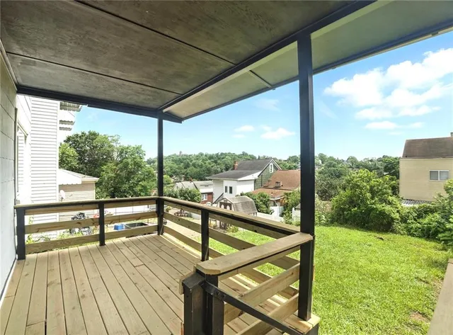 a view of a balcony with floor to ceiling windows with wooden floor
