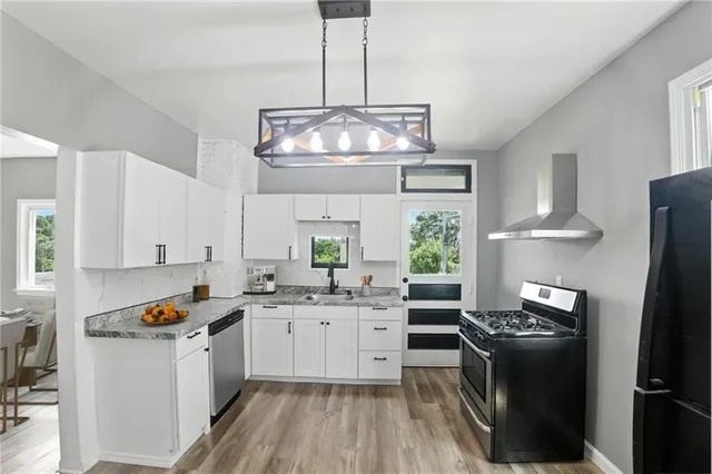 a kitchen with stainless steel appliances granite countertop a stove refrigerator and cabinets
