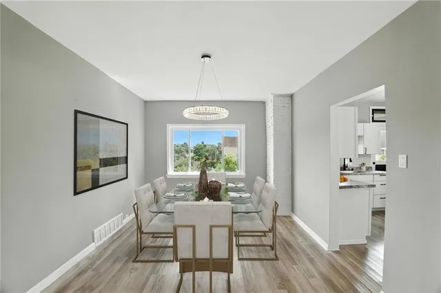 a dining room with furniture a chandelier and wooden floor