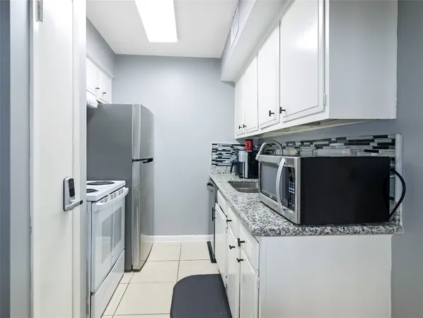 a kitchen with stainless steel appliances granite countertop a stove a refrigerator and a cabinets