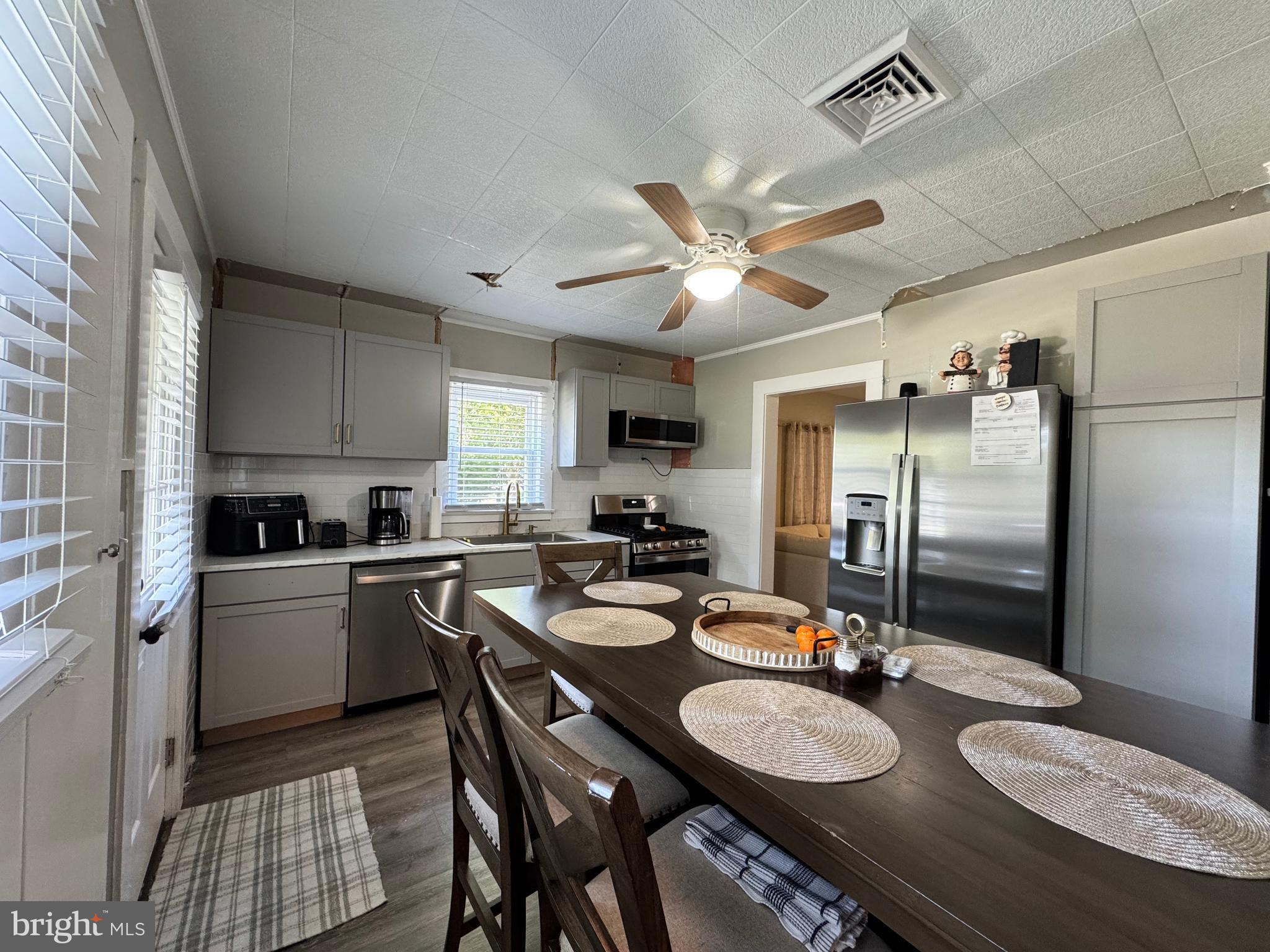 30483 Bennett Road Salisbury, MD 21804 - Photo 18 of 46 a kitchen with sink refrigerator dining table and chairs