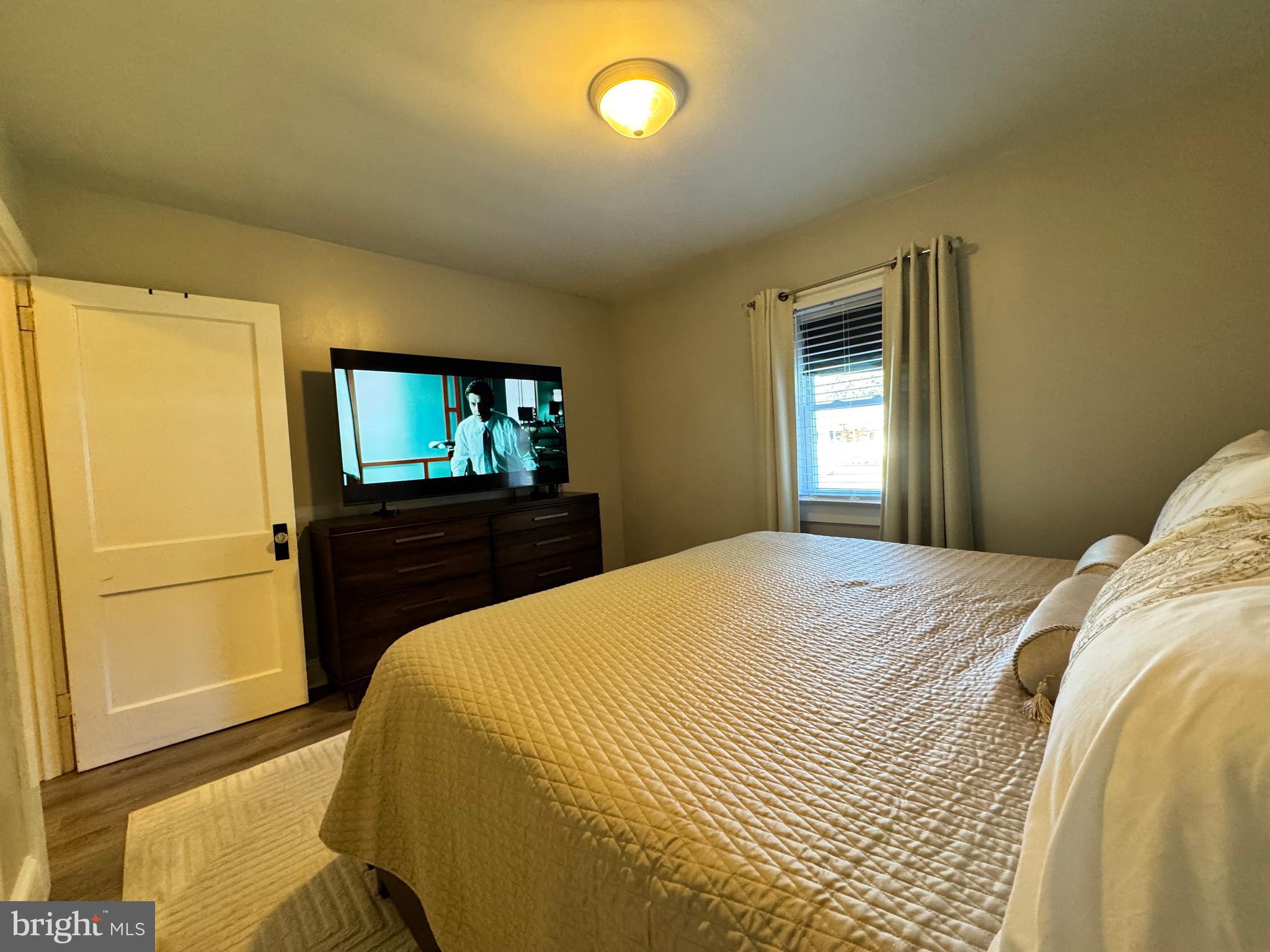 30483 Bennett Road Salisbury, MD 21804 - Photo 23 of 46 a bedroom with a bed and a flat tv screen on dresser