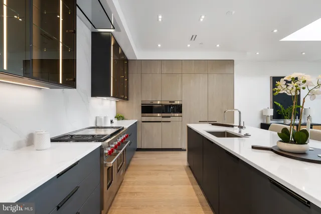 a kitchen with stainless steel appliances kitchen island granite countertop a table chairs microwave and sink