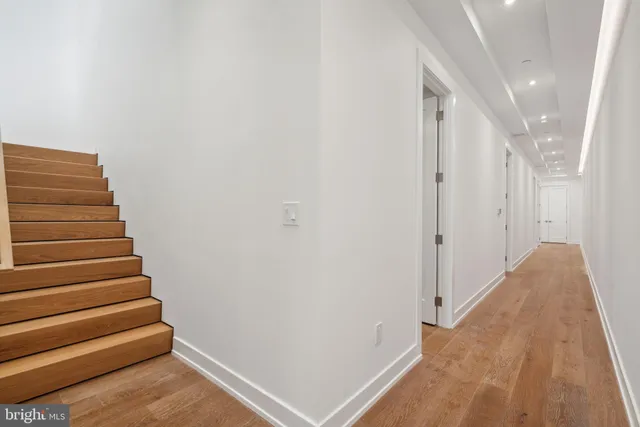 a view of a hallway with wooden floor and staircase