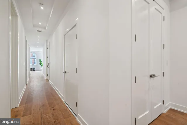a view of an empty room with wooden floor and windows