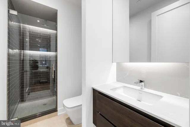 a bathroom with a sink a toilet and a mirror