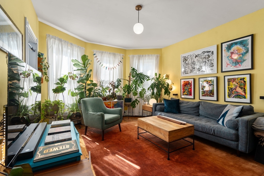 a living room with furniture fireplace and a large window