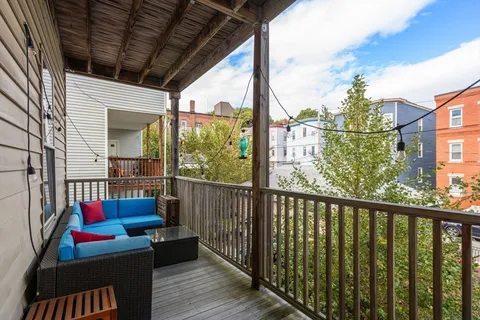 a view of a house with a small yard and large tree